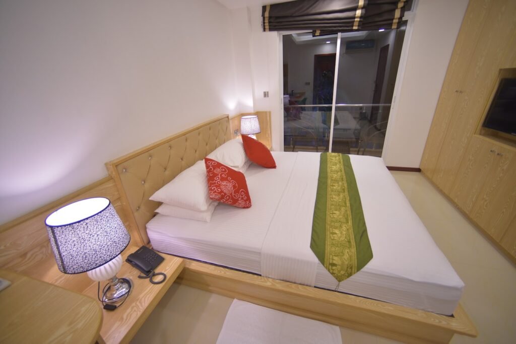 Spacious deluxe room at Hathaa Beach Maldives with sea view, modern amenities, and cozy bed