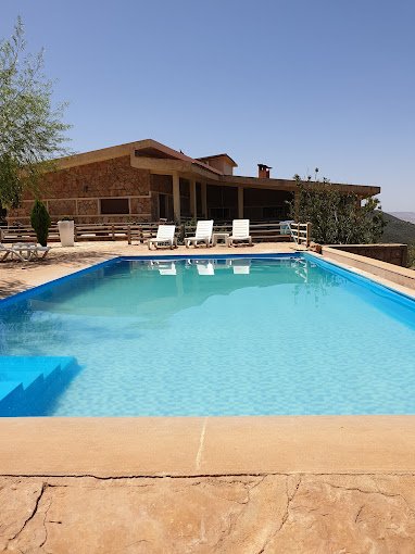 Outdoor pool at Rise In Valley hotel with mountain backdrop and family-friendly facilities.
