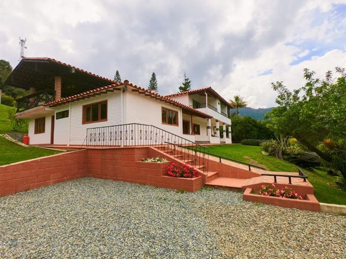 Exterior view of Chalets Villa Marina surrounded by green mountains in Copacabana, Colombia