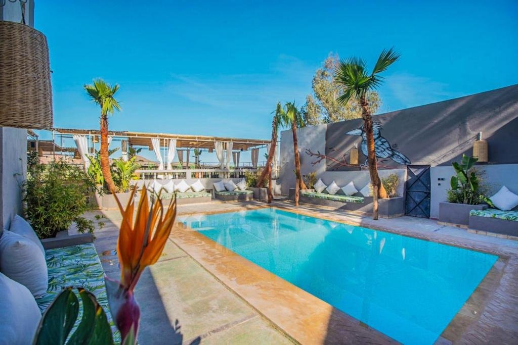 Outdoor swimming pool at LE Piccolo Bike Camp surrounded by countryside in El Karia, Morocco”