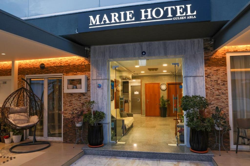 Exterior of Marie Hotel in Kos Town, Greece, with welcoming entrance and Mediterranean flowers