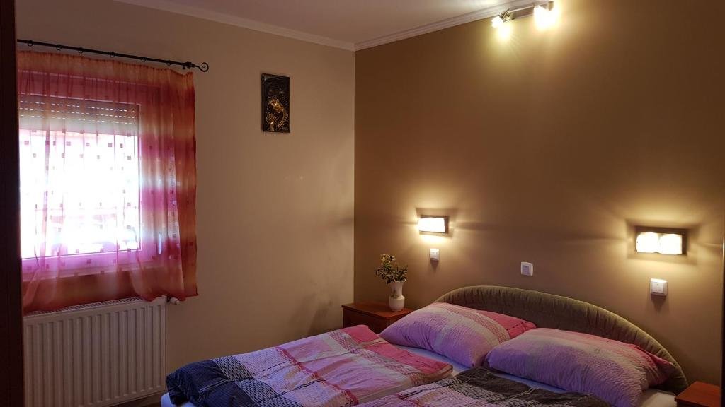 Comfortable bedroom inside Laci Apartman in Zalakaros, Hungary with natural light