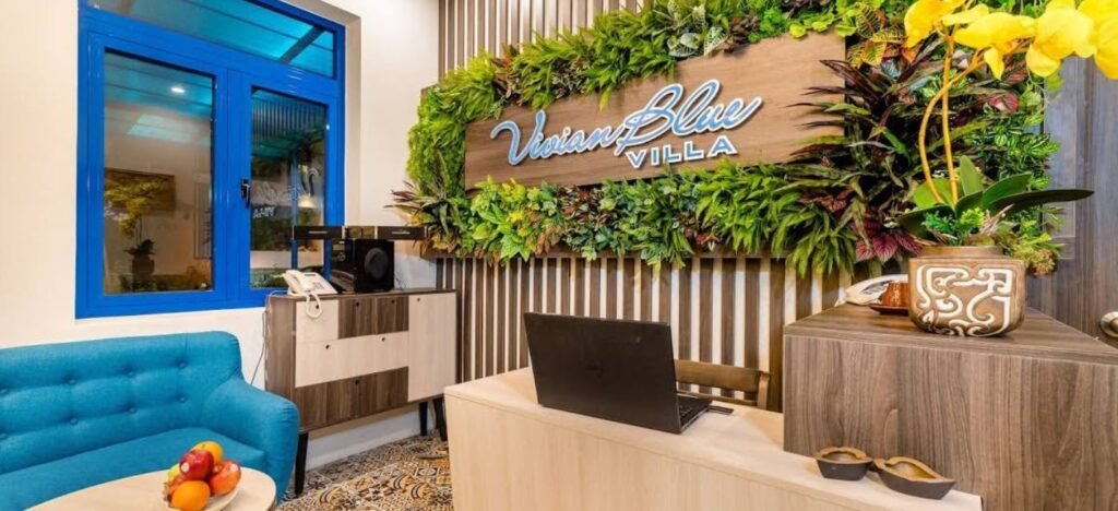 Entrance of Blue Boutique Villa Hoi An with palm trees and traditional Vietnamese design