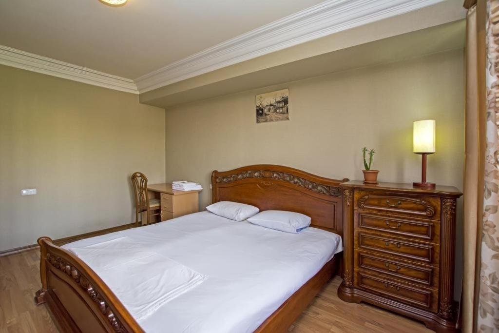 Comfortable bedroom at LeSi Apartament in Yerevan, Armenia, with fresh linens, a large bed, and city view from the window.